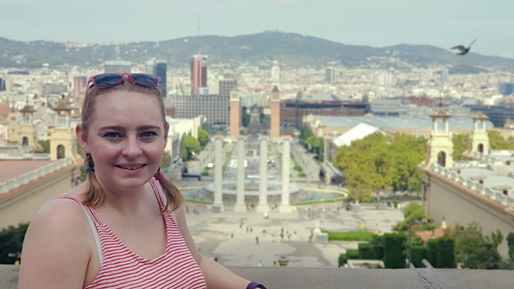 Zoe in Barcelona, stood on a hillside the city spans out behind her