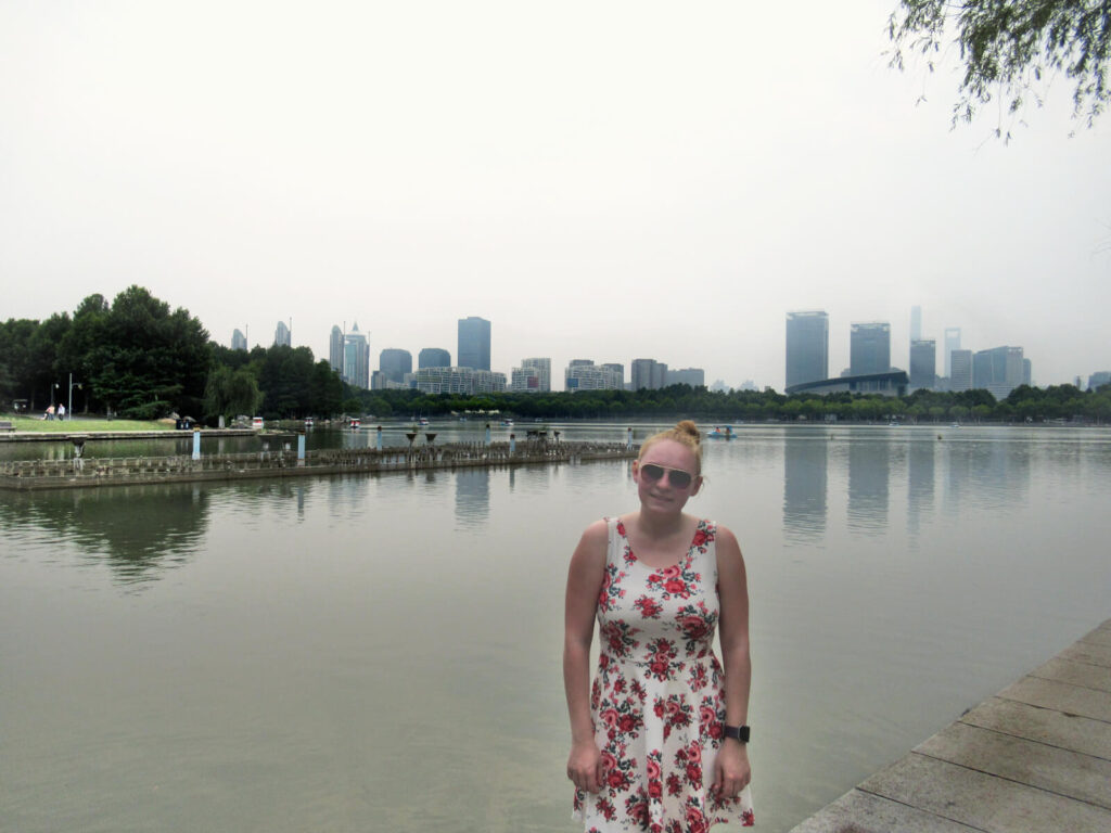Zoe in Century Park with the famous Shanghai skyline behind her, just visible on this overcast and smoggy day