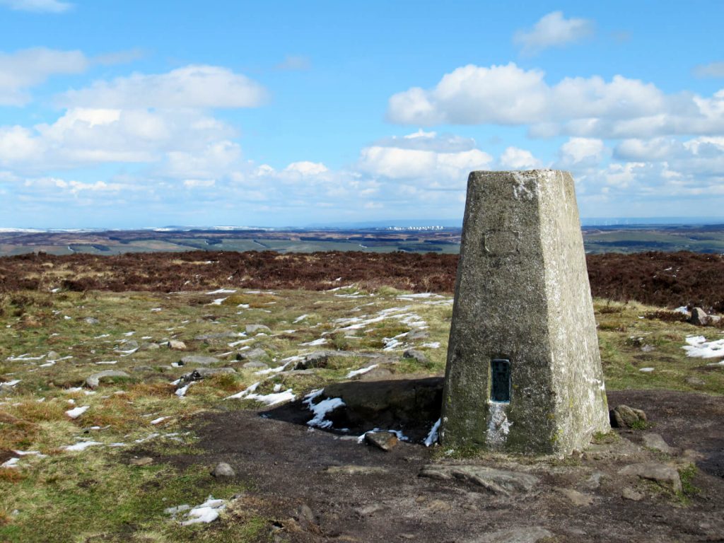 The highest point of Ilkley Moor - marked with a concrete trig point and overlooking the Yorkshire hills