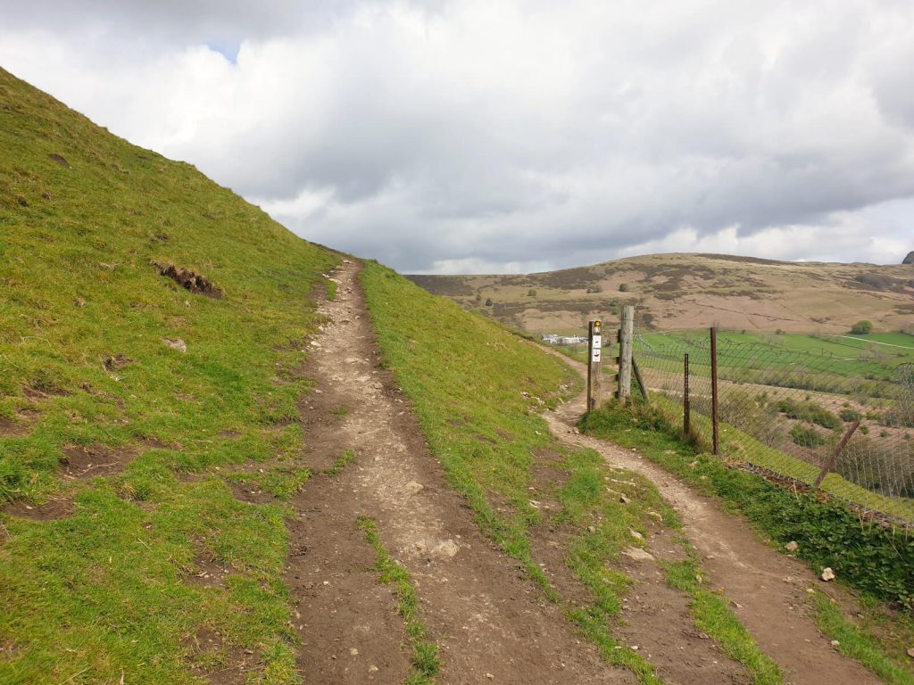 An uphill section of the Mam Tor walk from Castleton, the path is a mixture of dirt and small rock.
