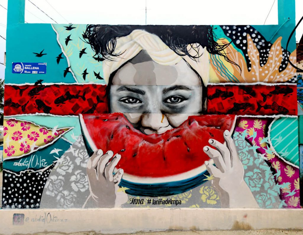 Street art in Holbox. A woman eats a slice of watermelon in the image