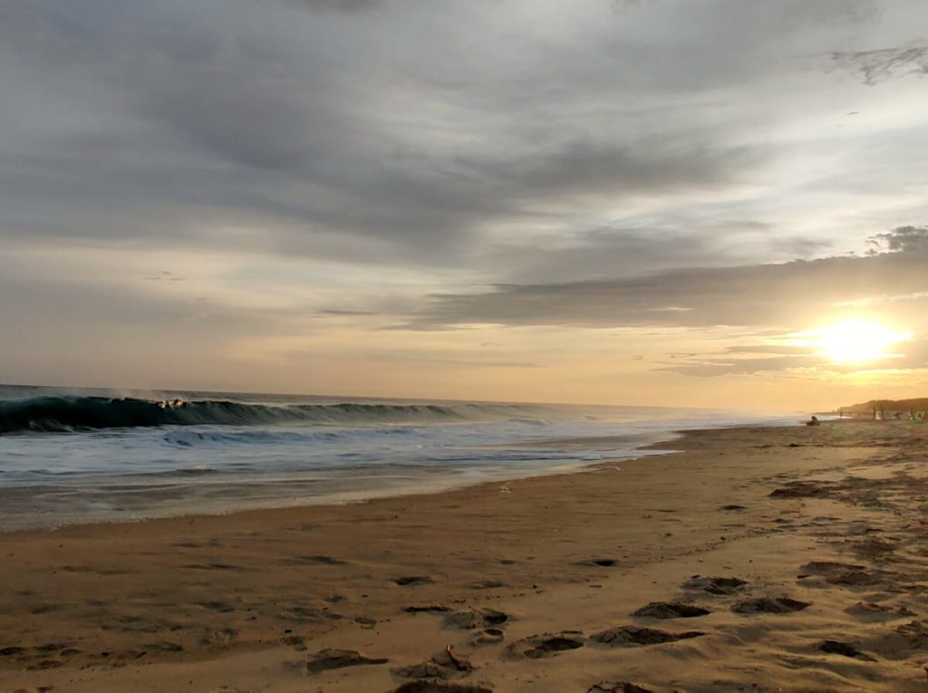 The sun sets over this Puerto Escondido beach as the waves crash against the shore